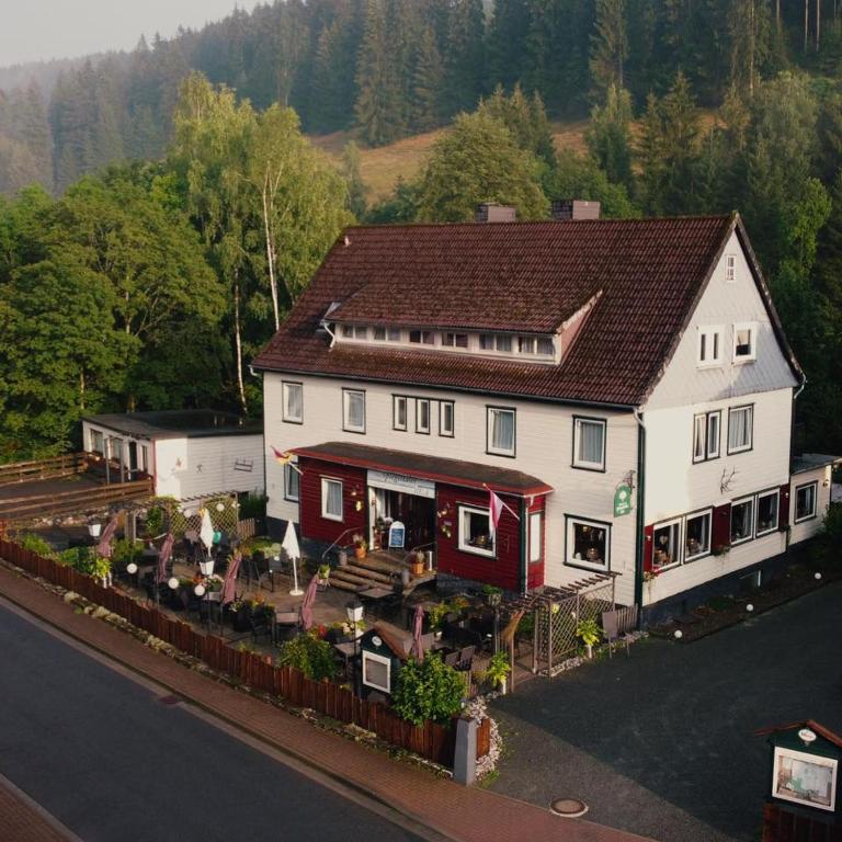 a large white and red house on the side of a road at hotel spiegeltaler eck in Wildemann