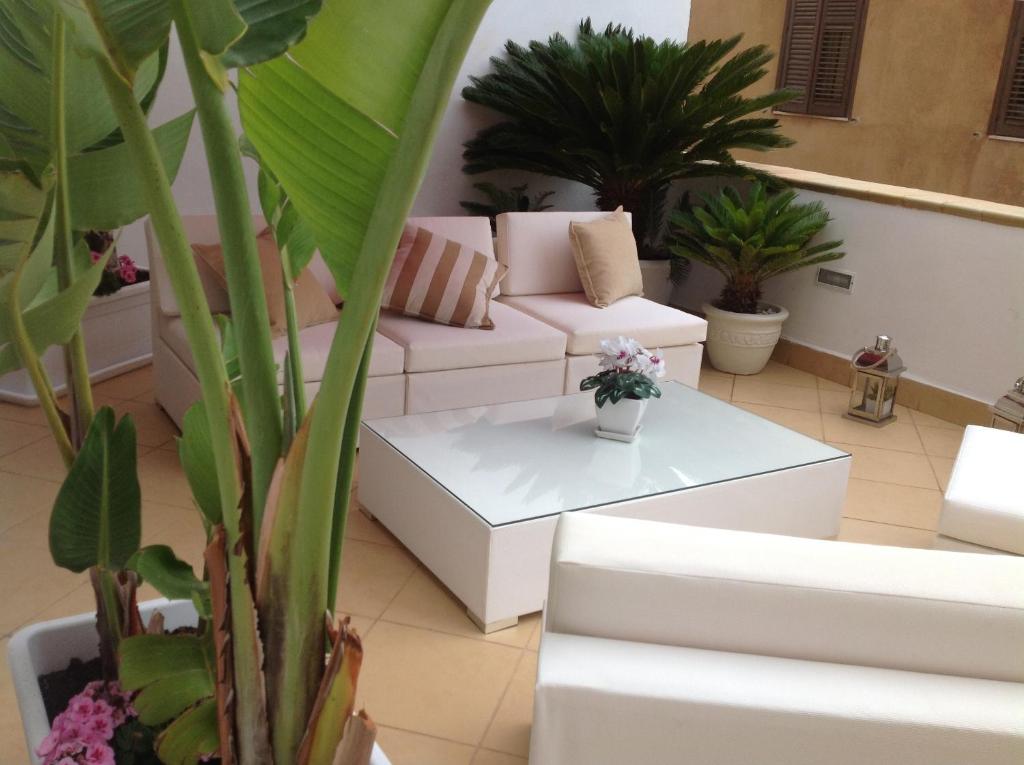 a living room with a white couch and potted plants at Best Suite Purgatorio in Marsala