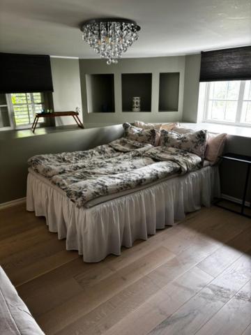 a large bed in a bedroom with a chandelier at Roslags Näsby Täby in Täby