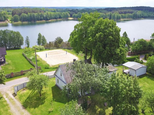 an aerial view of a house with a tennis court next to a lake at Sodyba Po liepom in Krikštonys