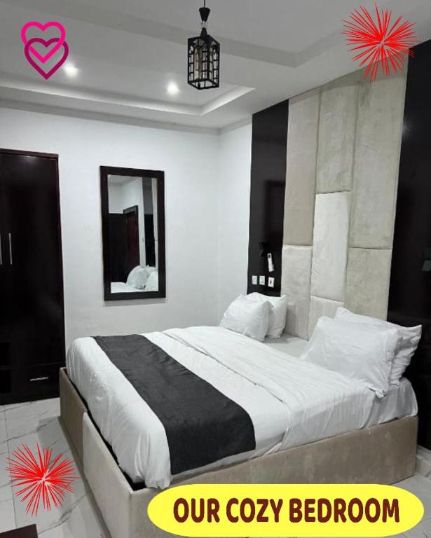 a bedroom with a bed with a black and white comforter at Britney Luxury Apartment in Owerri
