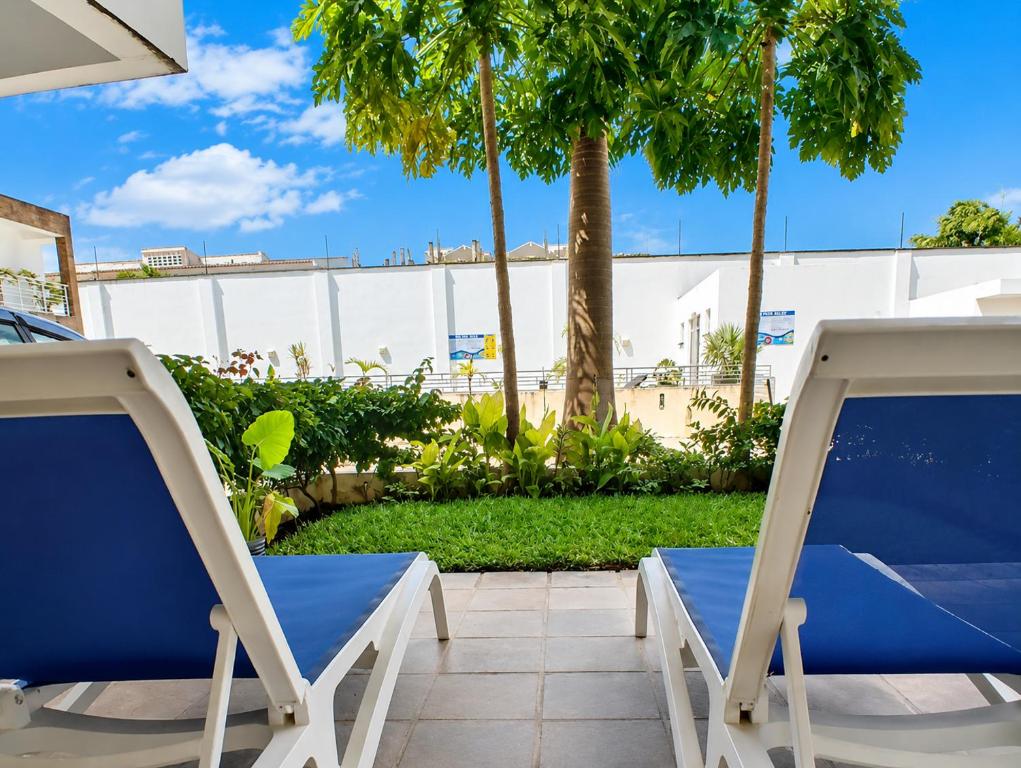 a pair of chairs on a patio with palm trees at Ary Homestay Nyali At Pearl Residence 3rd Avenue Nyali, Mombasa, Kenya in Nyali