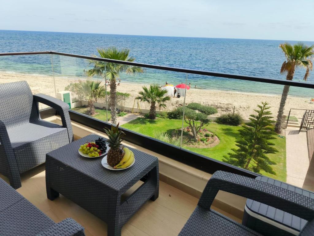 a balcony with a table and chairs and the beach at Beachfront Dream, WaveHaus in Akouda
