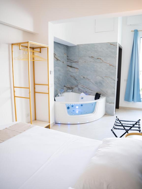 a white bedroom with a tub and a bed at Cenvi Suite - Jacuzzi rooms in Mola di Bari