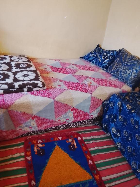 a bed with a quilt and pillows on it at Gîte Chez habitant in Telouet