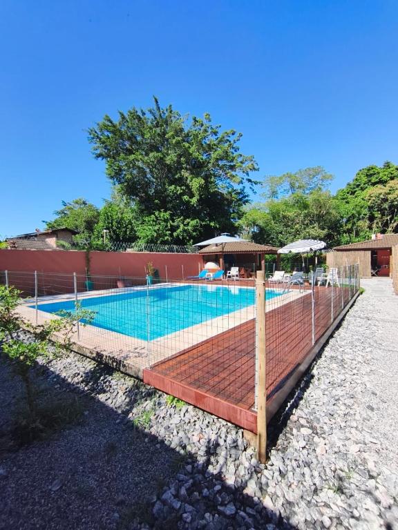 a fence around a swimming pool with a tennis court at Quinta do Sahy in São Sebastião