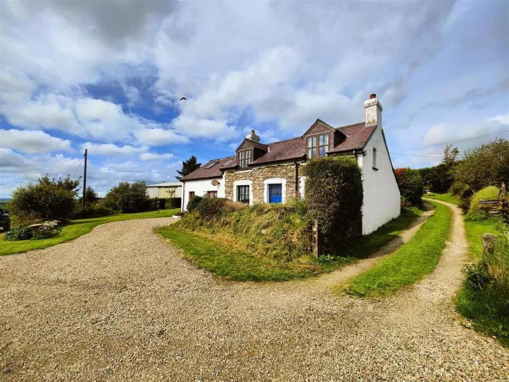 a house on the side of a gravel road at Ysgol Hill Main House in Rosebush