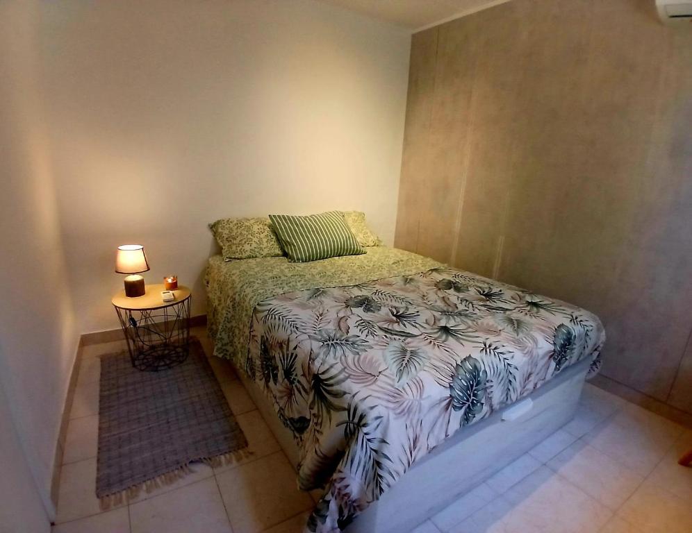 a small bedroom with a bed and a table at Casa de Férias Palmeira in Faro