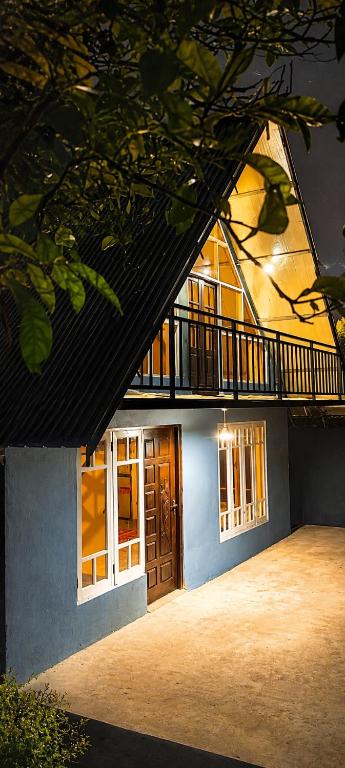 a house with a balcony on the side of it at Green Mountain Cabin in Nuwara Eliya