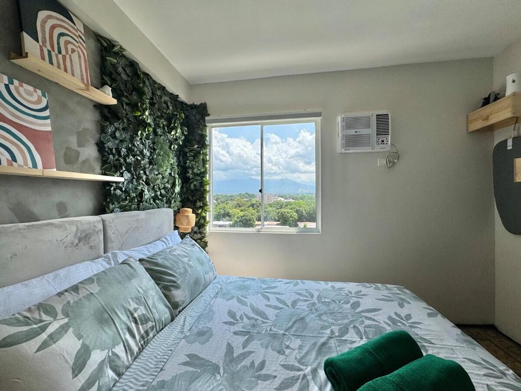 a bedroom with a bed and a large window at Marina Spatial Condo Unit 16 MountainView Studio in Piapi