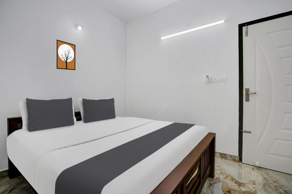 a bedroom with a large bed with a black and white at Hotel O EVA RESIDENCY in Cochin