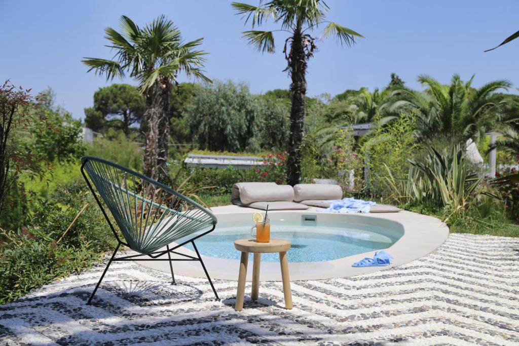 a patio with a chair and a table and a pool at Ekies All Senses Resort, a Member of Design Hotels in Vourvourou