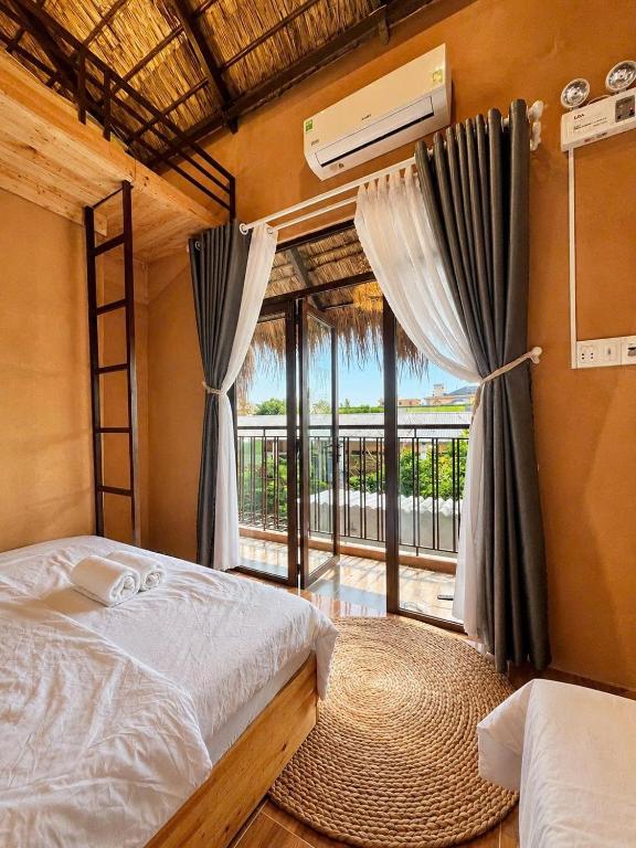 a bedroom with a bed and a large window at Tom Home Retreat in Mỹ Lại (1)