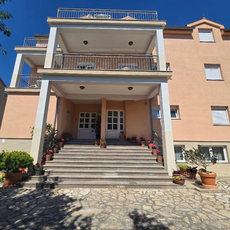 a large building with stairs and a balcony at Pansion Bonaca in Srima