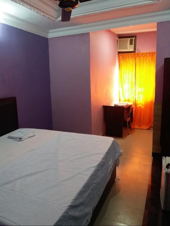 a bedroom with purple and orange walls and a bed at Seadry Suites in Dushepe