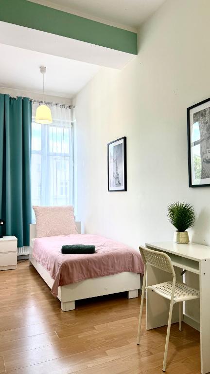 a bedroom with a bed and a desk and a chair at Beautiful Rooms - Park Kasprowicza in Szczecin