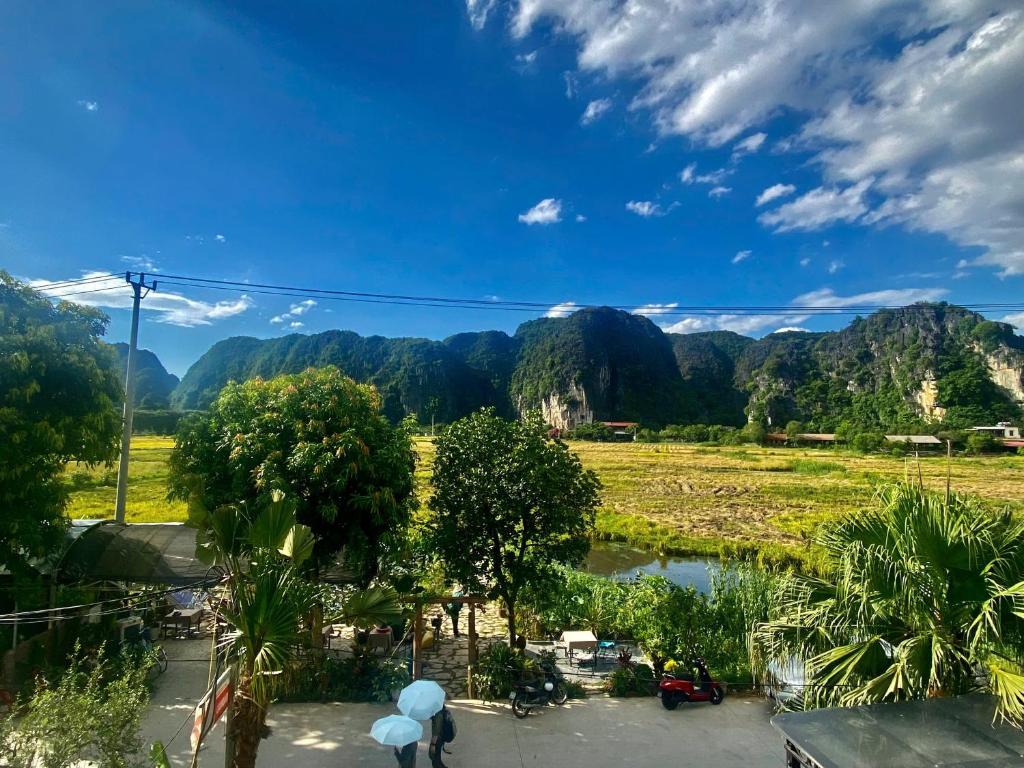 a view of a field with mountains in the background at Tam Coc Mountain View Homestay in Ninh Binh