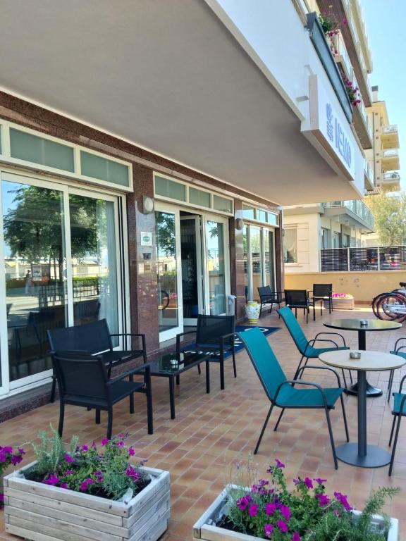 a patio with chairs and tables in front of a building at Hotel Nemo in Misano Adriatico