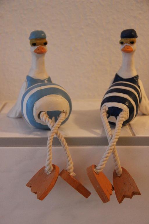 two figurines of two birds on a shelf at Ferienwohnung am Auensee in Leipzig