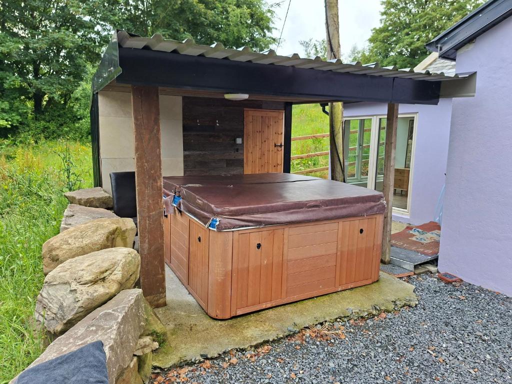 a hot tub in a building with a roof at Lakelands Cottage in Nenagh