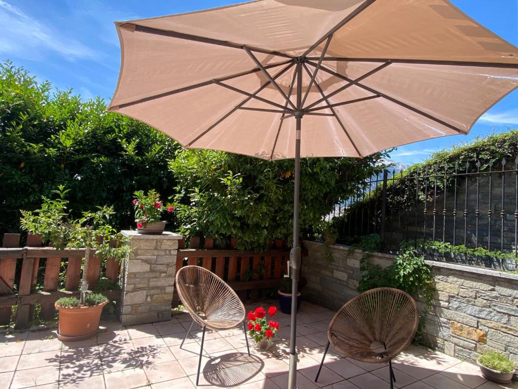 an umbrella and two chairs on a patio at Appartamento Catalina in Saint-Pierre