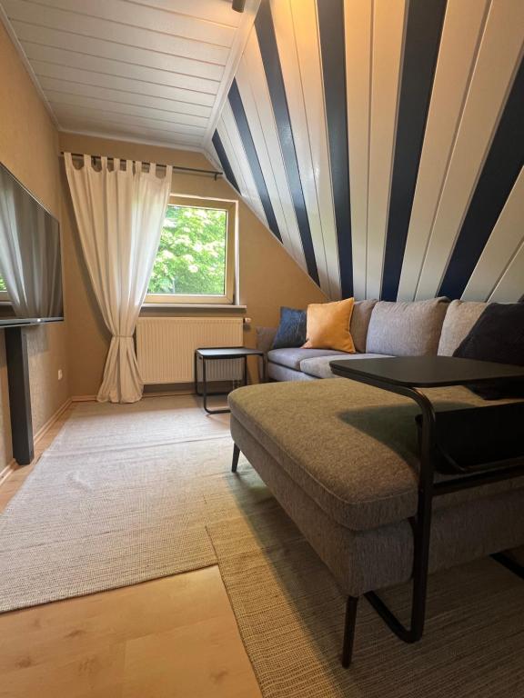 a living room with a couch and a window at Ferienwohnung Blumenthal bei Kiel in Blumenthal