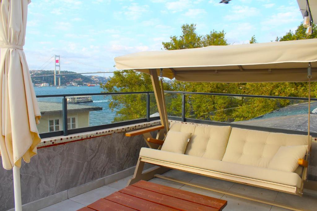 a balcony with a couch and an umbrella at Kuzguncuk View in Istanbul