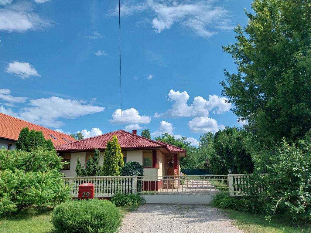 a house with a white fence in a yard at Mangó Vendégház in Balatonszárszó