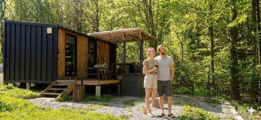 a man and woman standing in front of a tiny house at evkalipt in Ivano-Frankivsk