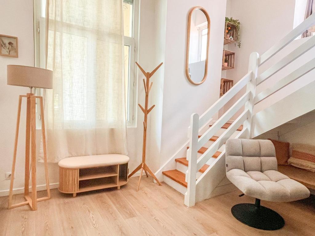 a living room with a staircase and a chair at Large 2 bedrooms Duplex - City Center & free Parking in Arcachon