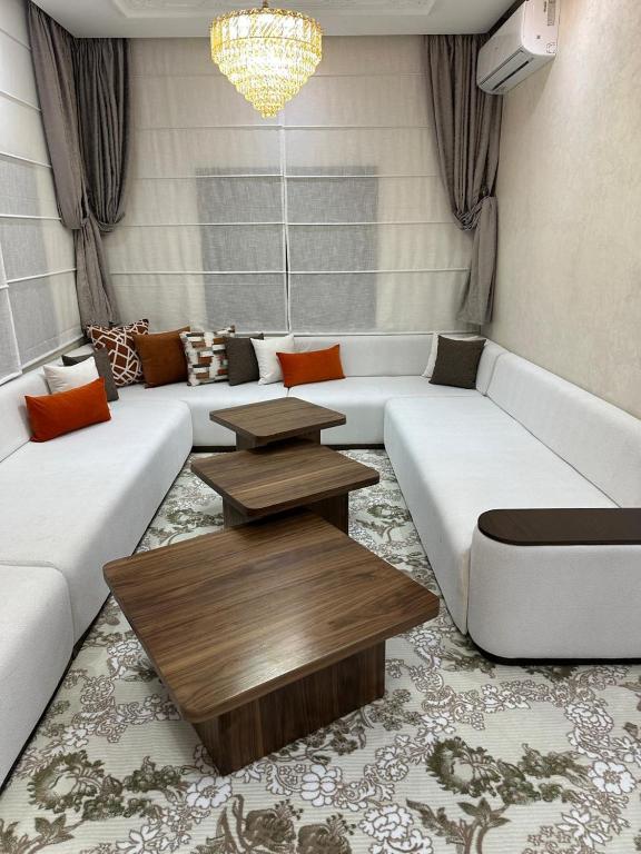 a living room with white couches and a table at villa privée ghmat in Marrakesh