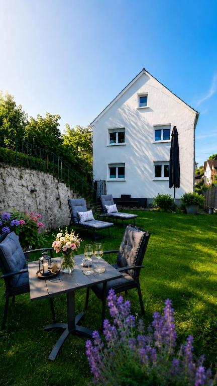 a table and chairs in a yard with a house at Ferienwohnung Elya Gartenparadies nahe Events, Outlet und Spa in Bad Münstereifel