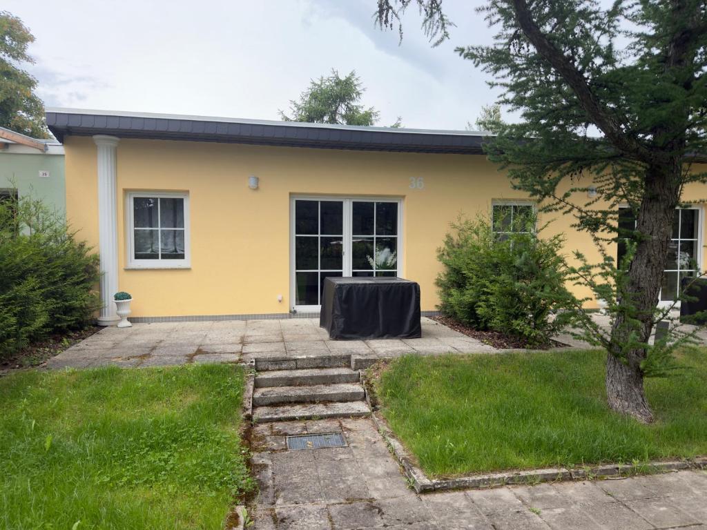 a yellow house with a table in the front yard at Casa Mia 36 am See in Joachimsthal