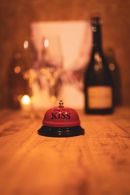 a red hat sitting on a table next to a bottle at Atelier 69 Loveroom in Paliseul