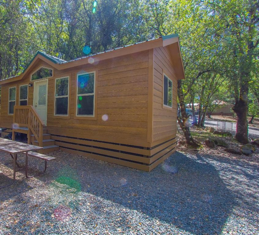 a small cabin with a bench in front of it at Ponderosa Camping Resort One-Bedroom Cabin 4 in Lotus