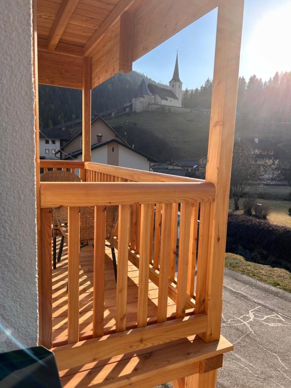 a wooden balcony with a view of a church at MyAlpenloft 2 in Deutschgriffen