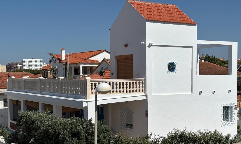 a white house with a balcony and a street light at El Chalet in Punta Umbría