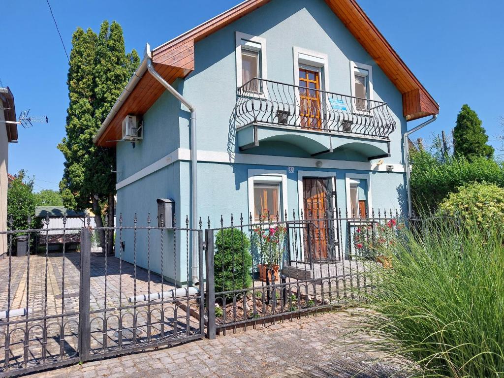 a house with a fence in front of it at Azúr Vendégház in Hajdúszoboszló
