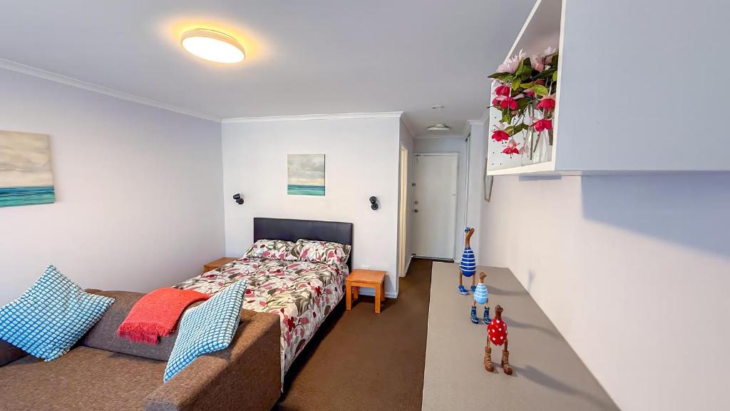 a bedroom with a bed and a couch in a room at Mandurah Coastal Studio - Pool Outlook in Mandurah