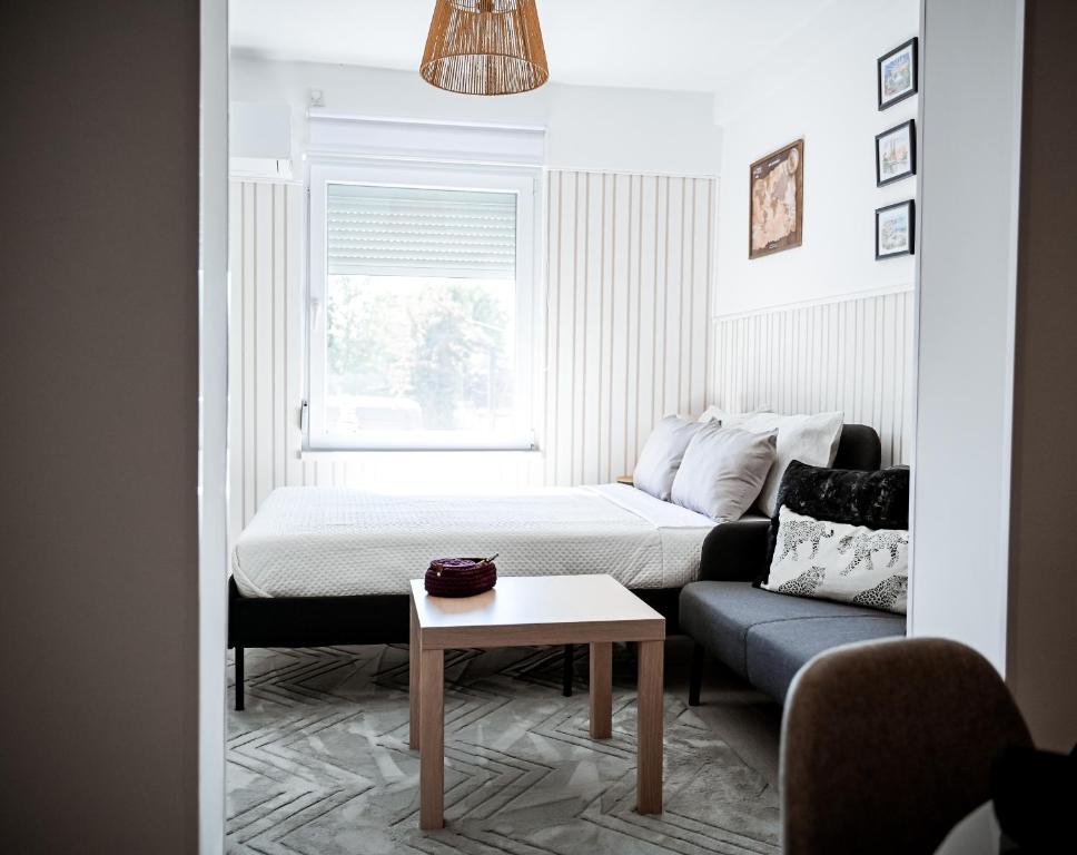 a bedroom with a bed and a couch and a table at Nexus Apartman in Apatin