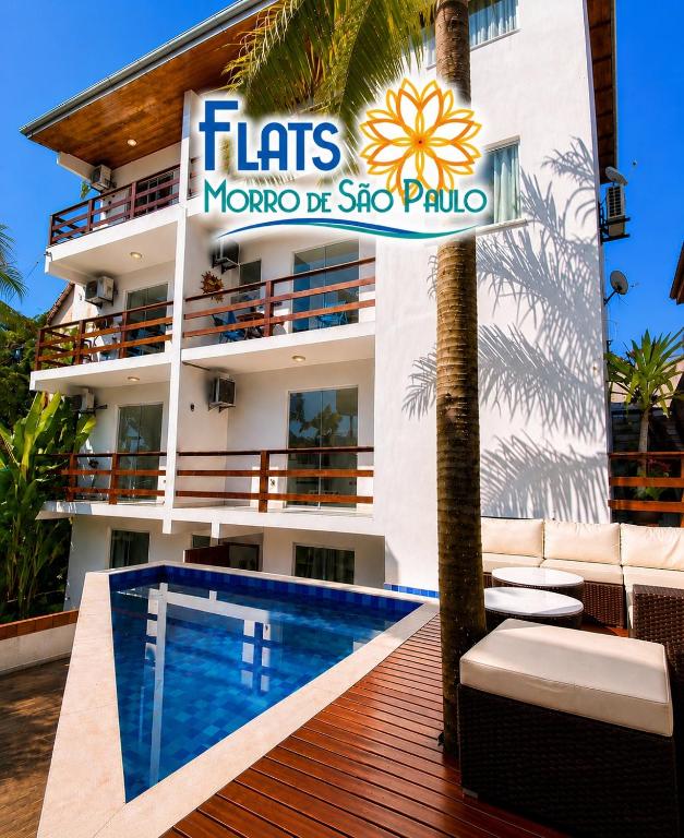 a hotel with a swimming pool in front of a building at Flats Morro de São Paulo in Morro de São Paulo