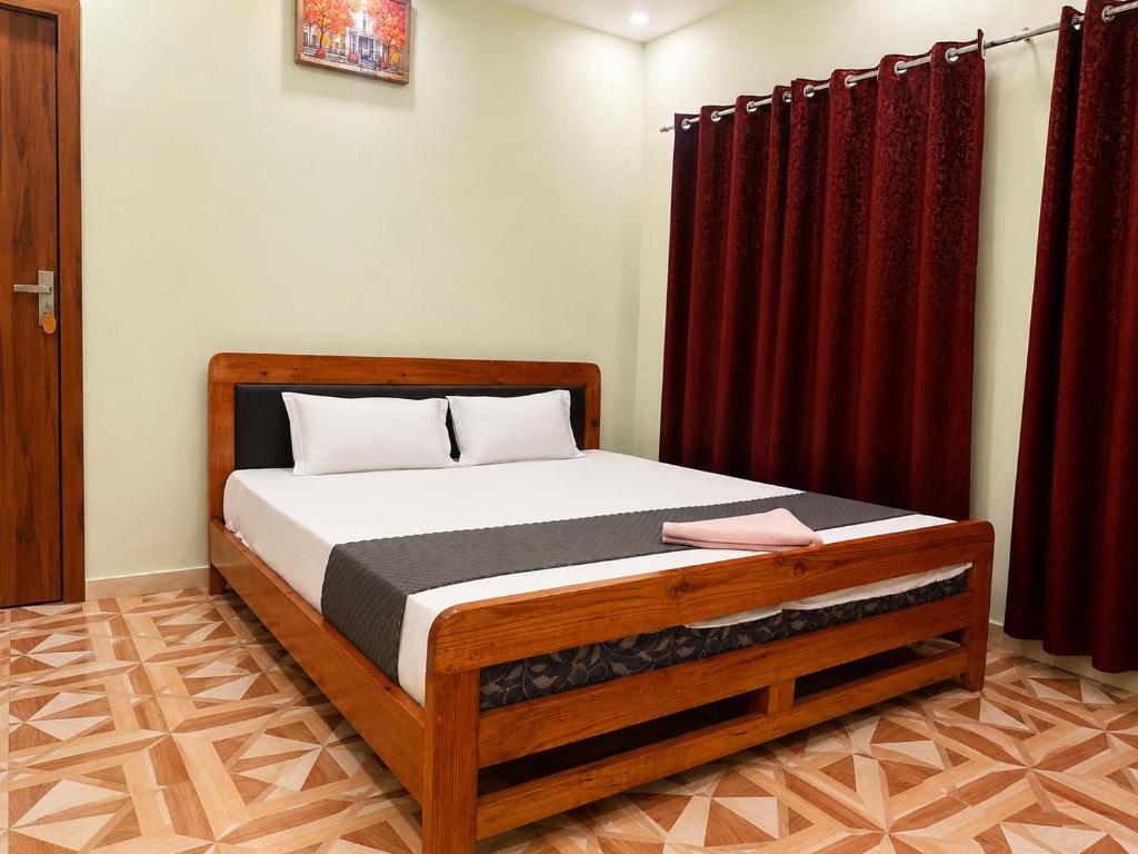 a bed in a room with red curtains at Lila Palace in Nepālganj