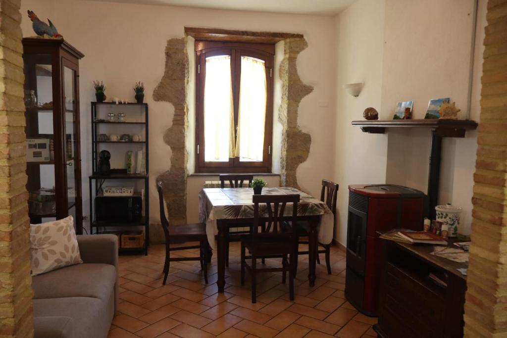 a living room with a table and chairs and a window at Eva'house in Bolsena