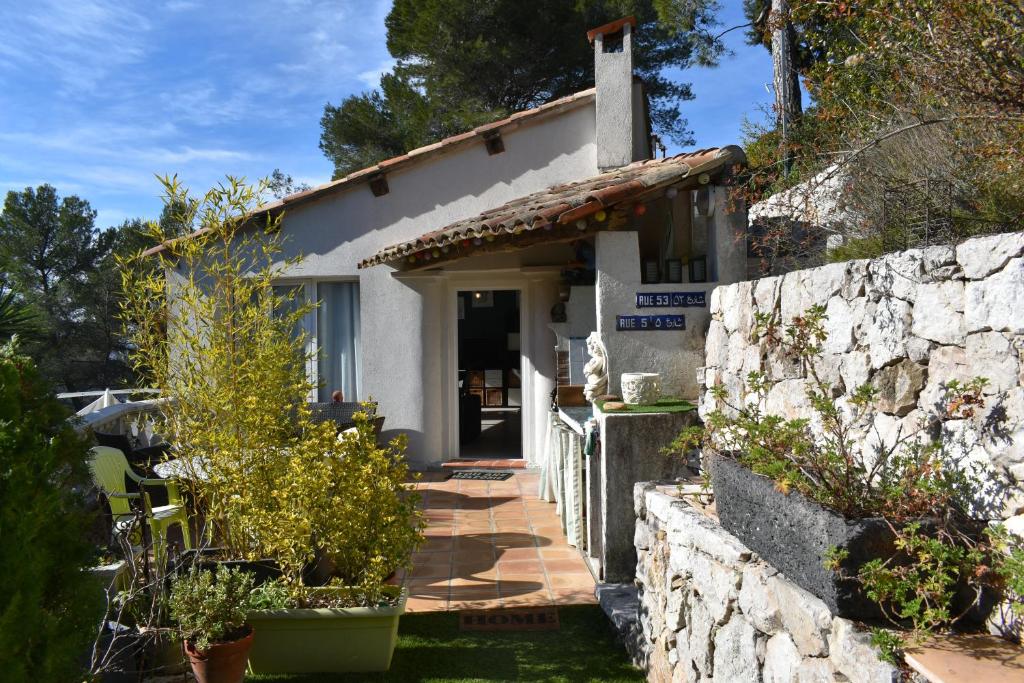 a small white house with a stone wall at Tiny house - Drap, France in Drap