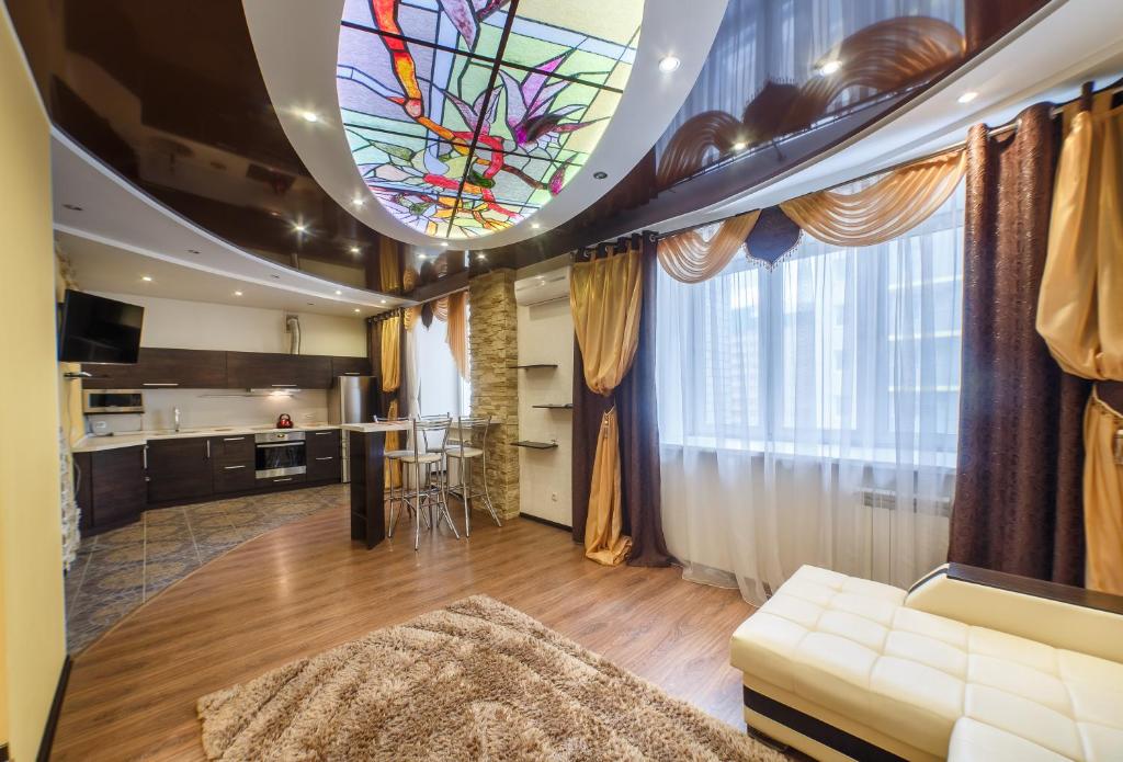 een woonkamer met een bank en een glas-in-loodplafond bij Adoratskogo Apartment in Kazan