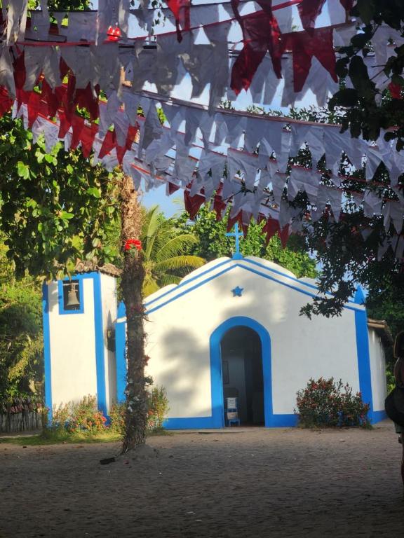 a blue and white building with a door and flags at Pousada Aldeia Do Mar - Caraíva BA in Caraíva