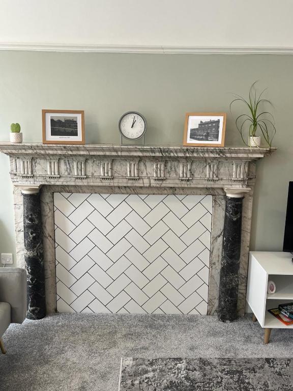 a fireplace with a clock on top of it at Stunning 2 bed apartment - central Norwich in Norwich