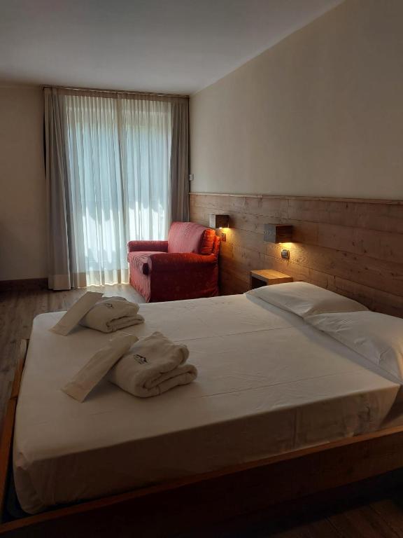 a bedroom with a large bed with towels on it at Hotel Cristallo in Sestriere