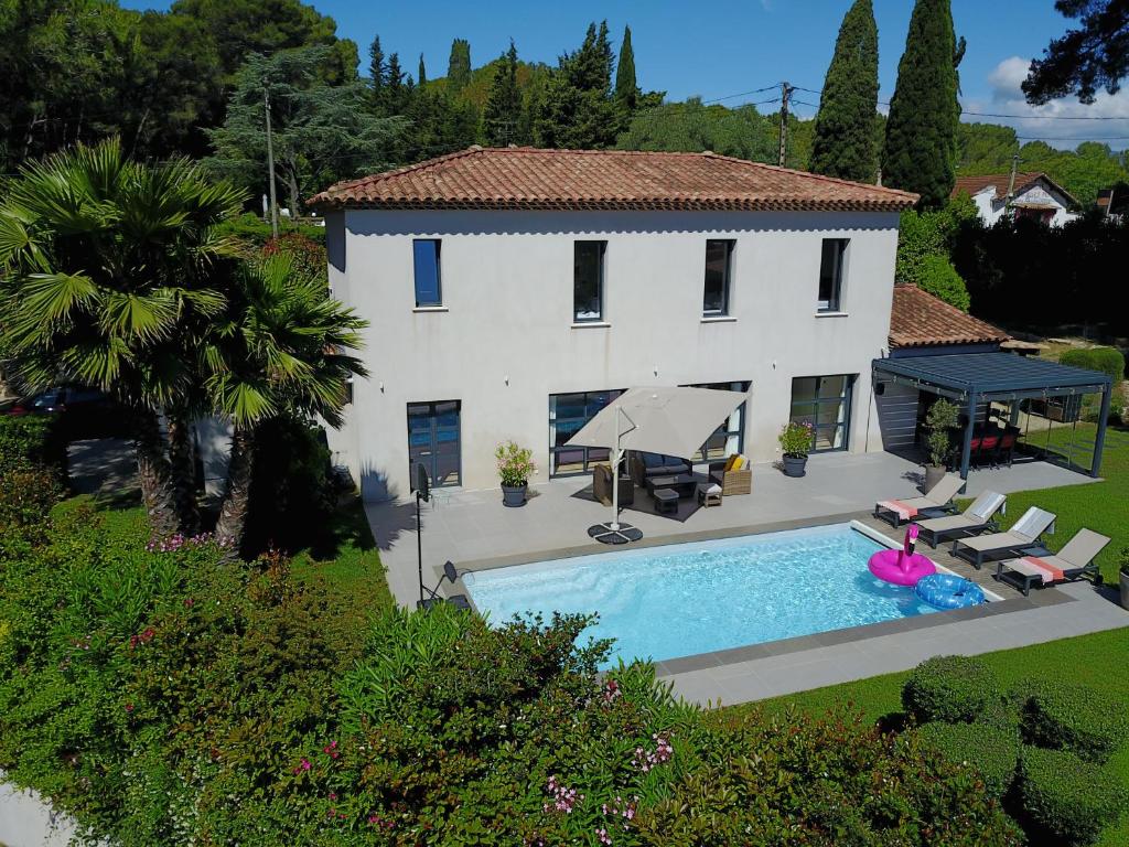 a villa with a swimming pool in front of a house at Villa Les Jasmins - Le Cannet-Vallauris - Modern with AC, ideal for fun and work in Vallauris