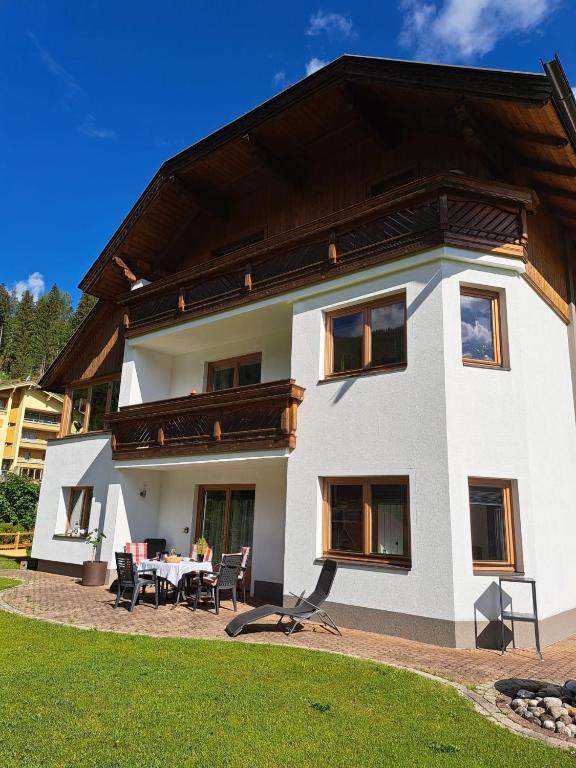 a large white house with a table and chairs at Ferienwohnung Haus Ebner in Patergassen